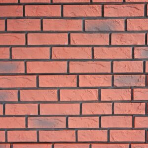 Close-up of a faux red brick panels with black grout lines