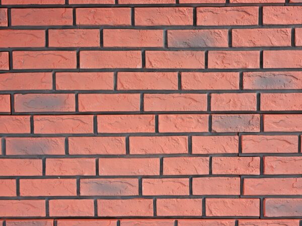 Close-up of a faux red brick panels with black grout lines